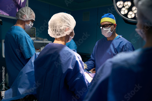 Surgeon, anesthetist and assistants work at the operating table