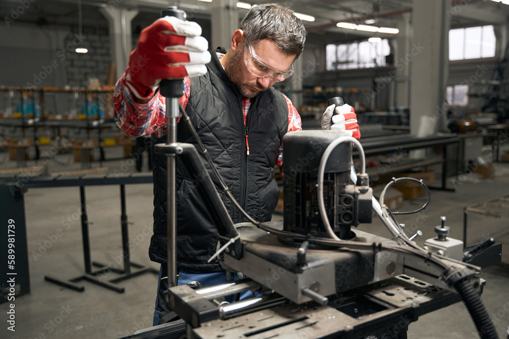 Obraz premium Adult male working on equipment in the workshop