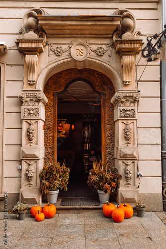 View of old building with red wooden door and steps.Pumpkins decoration for the street  selective focus. High quality photo