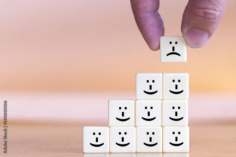 Stack of blocks with happy face icons. A single block with a sad face