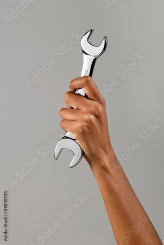 Crop black woman showing wrench