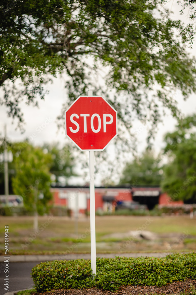 Stop sign outside on the road in North America with a building behind Stop sign outside on the road in North America with a building behind