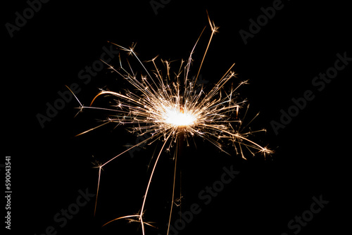 Burning sparkler isolated on black background. Fireworks theme. Light effect and texture.