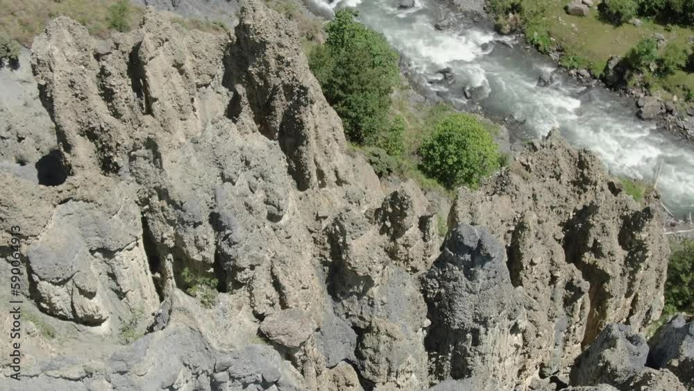 Flying over stony rock mountainside, rocky river and trees. Amazing mountain view from aerial shooting Flying over stony rock mountainside, rocky river and trees. Amazing mountain view from aerial shooting