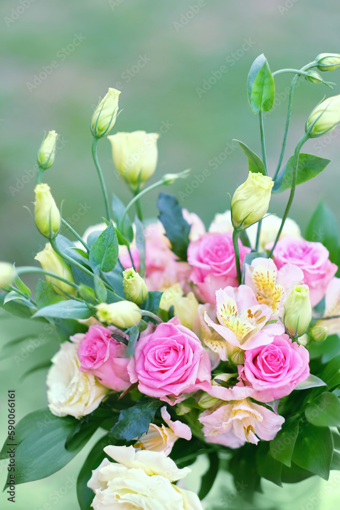 beautiful bouquet with eustoma and roses flowers close up on abstract blurred green background. Gentle romantic floral festive image. template for design. copy space