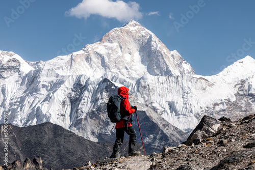 Hiker in red jacket admiring west face of Makalu (8481m) after crossing Kongma-la pass on Three passes trek photo