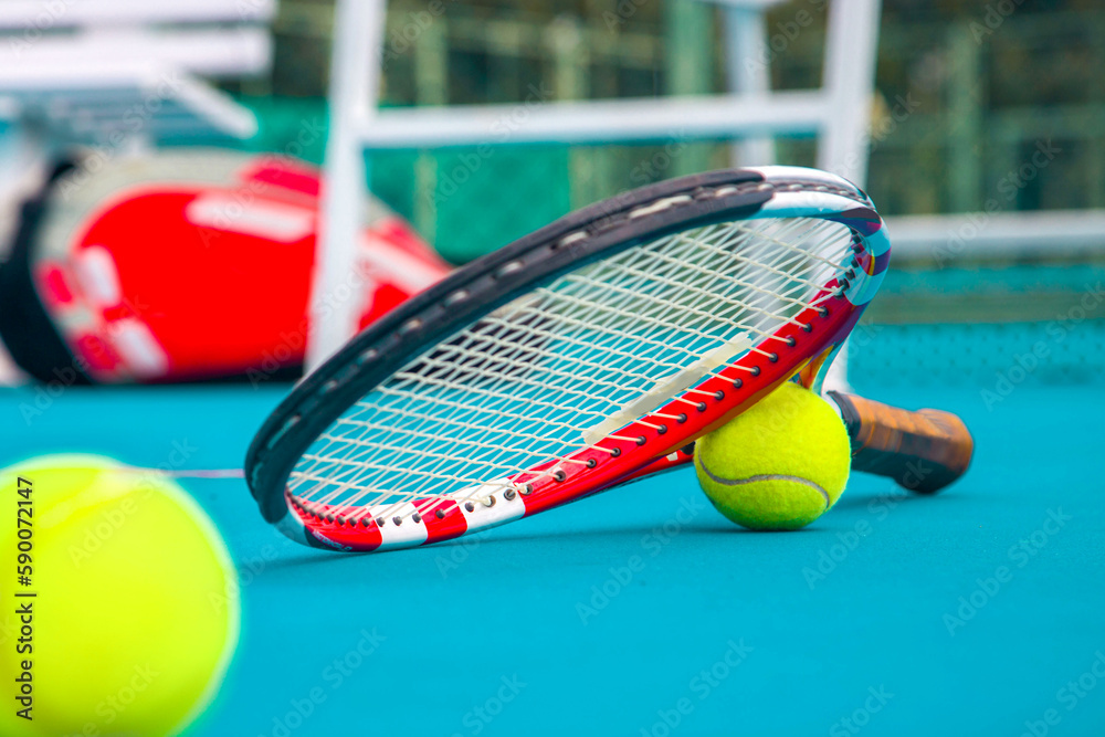 Tennis racket and ball on the blue-coated court