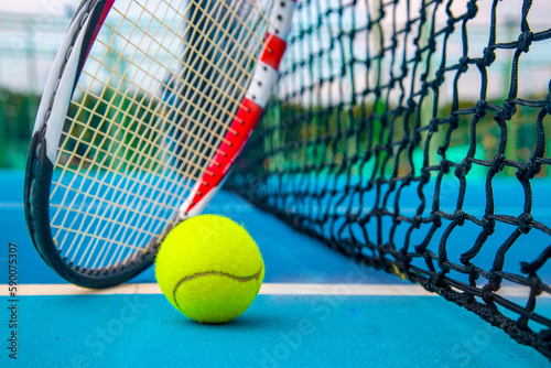 Tennis racket and ball on the blue-coated court