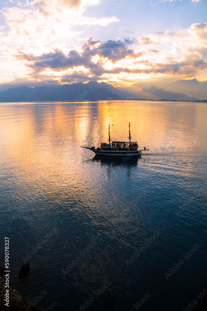 Landscape of boat - yacht in the Mediterranean sea with mountains in the distance during the sunset, Antalya, Turkey Landscape of boat - yacht in the Mediterranean sea with mountains in the distance during the sunset, Antalya, Turkey