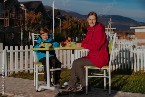 Mother and son drink tea in the yard of a country house © chaossart