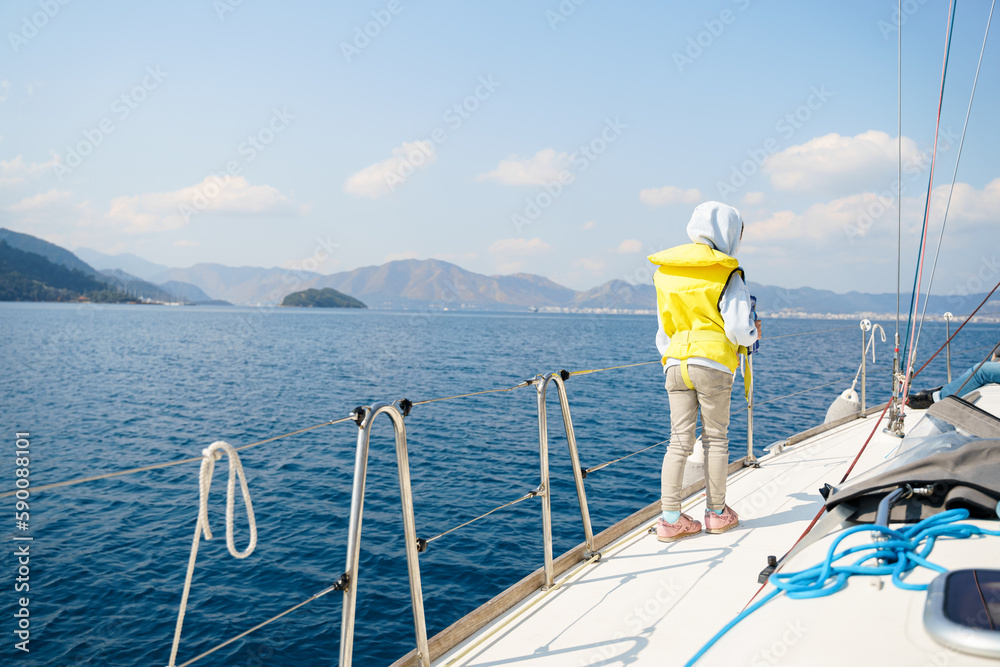 Voyage sail on sport sea luxury yacht. Yachting family summer vacation cruise. Children, sailor kid girl sailing in little safe life jacket. Ocean ship boa travel. Enjoy trip on sailboat front deck