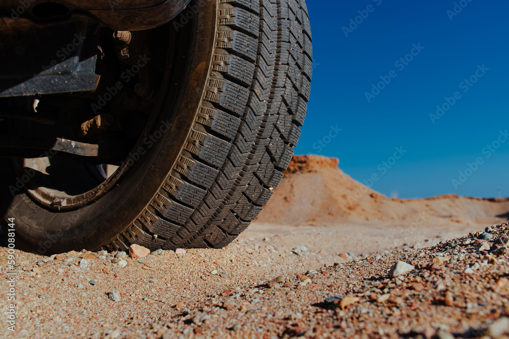 Car wheel on sand close-up view