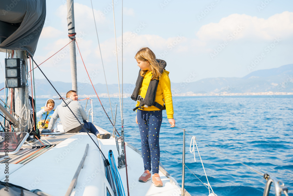 Voyage sail on sport sea luxury yacht. Yachting family summer vacation cruise. Children, sailor kid girl sailing in little safe life jacket. Ocean ship boa travel. Enjoy trip on sailboat front deck Voyage sail on sport sea luxury yacht. Yachting family summer vacation cruise. Children, sailor kid girl sailing in little safe life jacket. Ocean ship boa travel. Enjoy trip on sailboat front deck