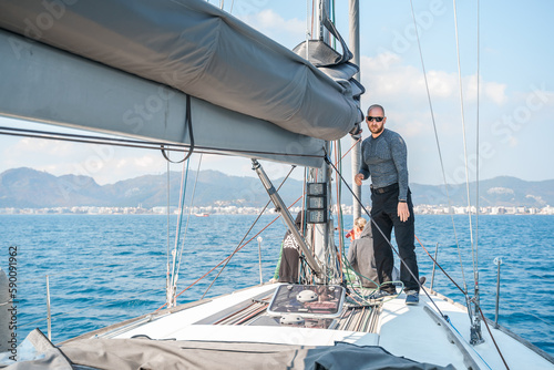 Voyage race sail on professional sport sea yacht. Yachting summer vacation cruise . Captain yachtsman sailing. Sails on mast. Ocean ship boa travel. Enjoy trip on sailboat front deck. Training school