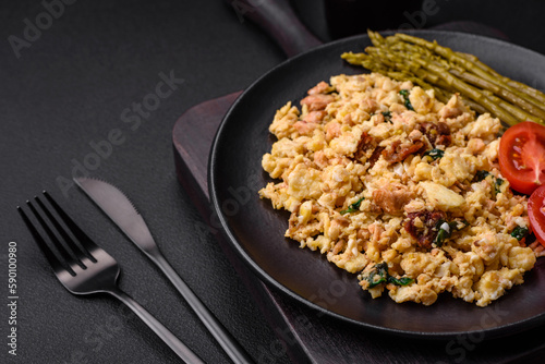 Delicious scramble with salmon, sun-dried tomatoes, spinach, spices and herbs