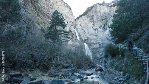 high waterfall next toa fresh water river in the pyrenees