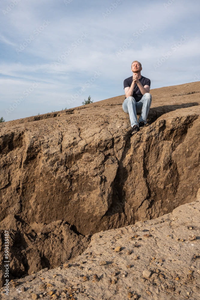 Naklejka premium A man surrounded by mountains. Hope, faith and prayer