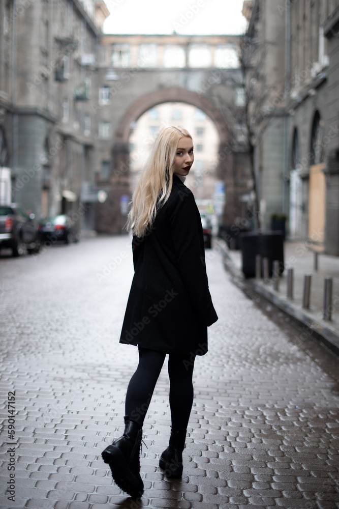 young woman walking city streets and look behind at camera