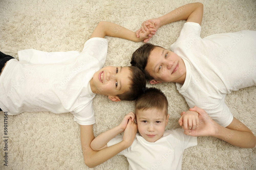 Happy intergenerational 3 three men family concept lying in circle close up portrait, child boy son grandson, young adult father and old grandfather laugh bonding look at camera