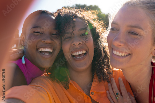 Portrait of happy diverse female friends embracing and smiling at beach, with copy space