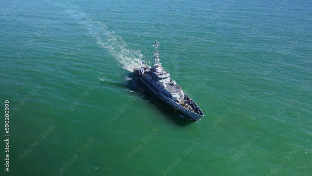 UK Border patrol ship sailing along iconic British coastline on sunny day