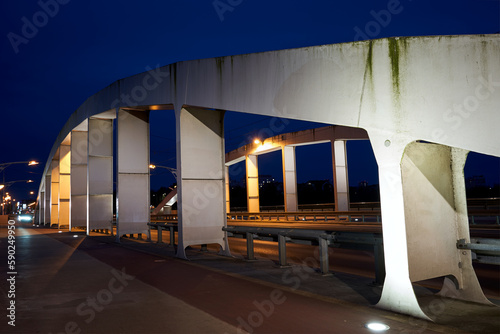 The steel structure of the road bridge over the Warta River during the night in the city of Poznan