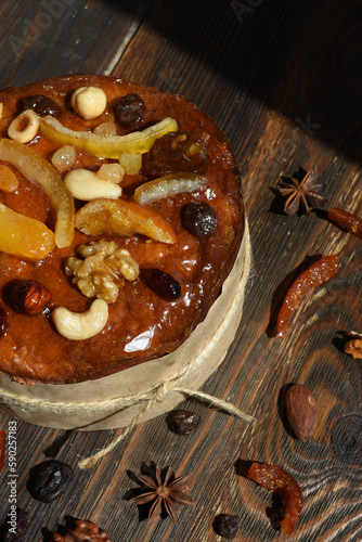 Easter cake with candied fruits and nuts on dark wooden background.Traditional Easter treat,symbol.Top view. Vertical