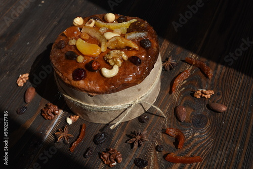 Easter cake with candied fruits and nuts on dark wooden background.Traditional Easter treat,symbol.Top view. Copy space
