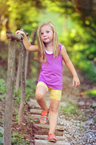 A little girl is walking in the nature.