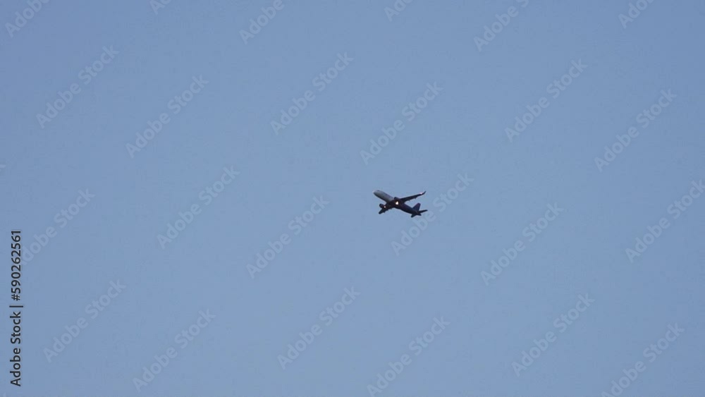 A civil plane flies against the background of the blue sky. A civil plane flies against the background of the blue sky.