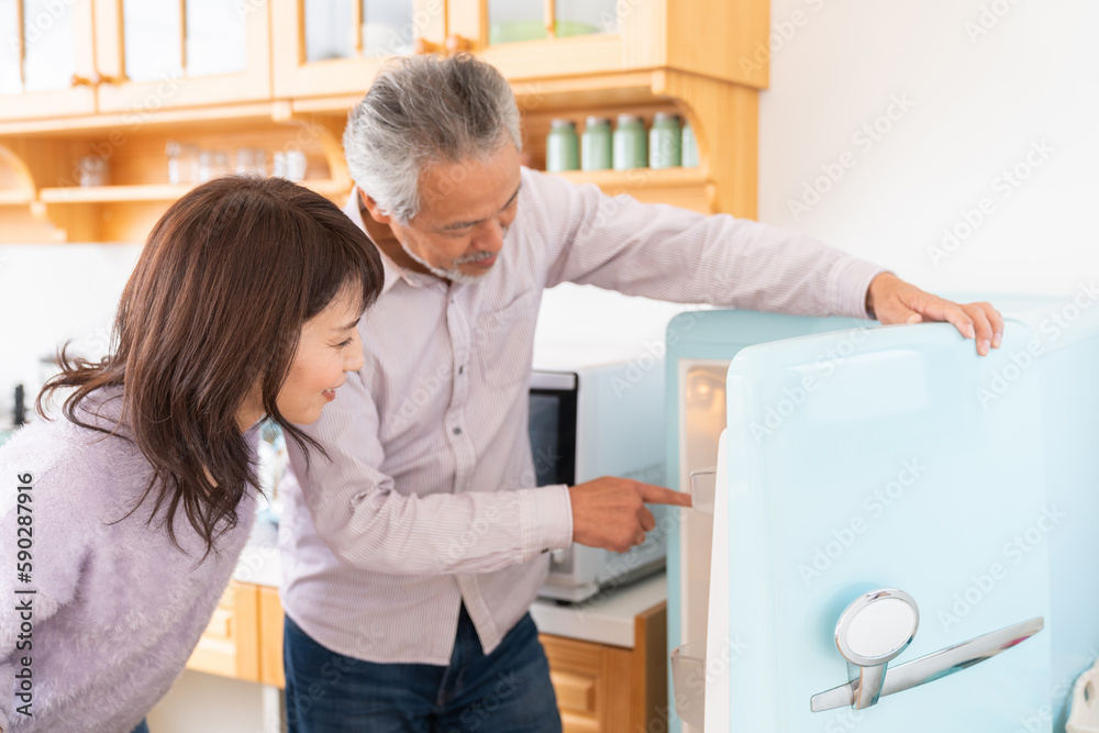 Obraz premium 料理をするミドル 夫婦 冷蔵庫