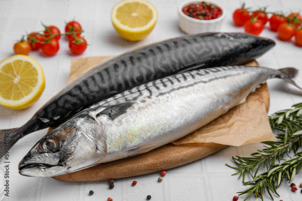 Raw mackerel and rosemary on white table Raw mackerel and rosemary on white table