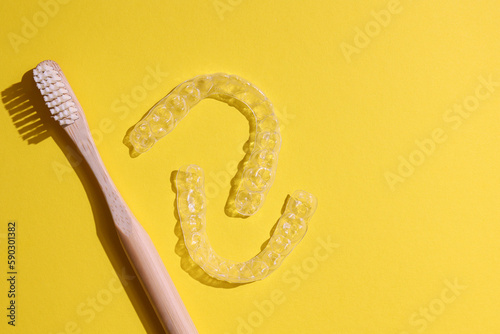 Transparent plastic dental aligners on a colored background