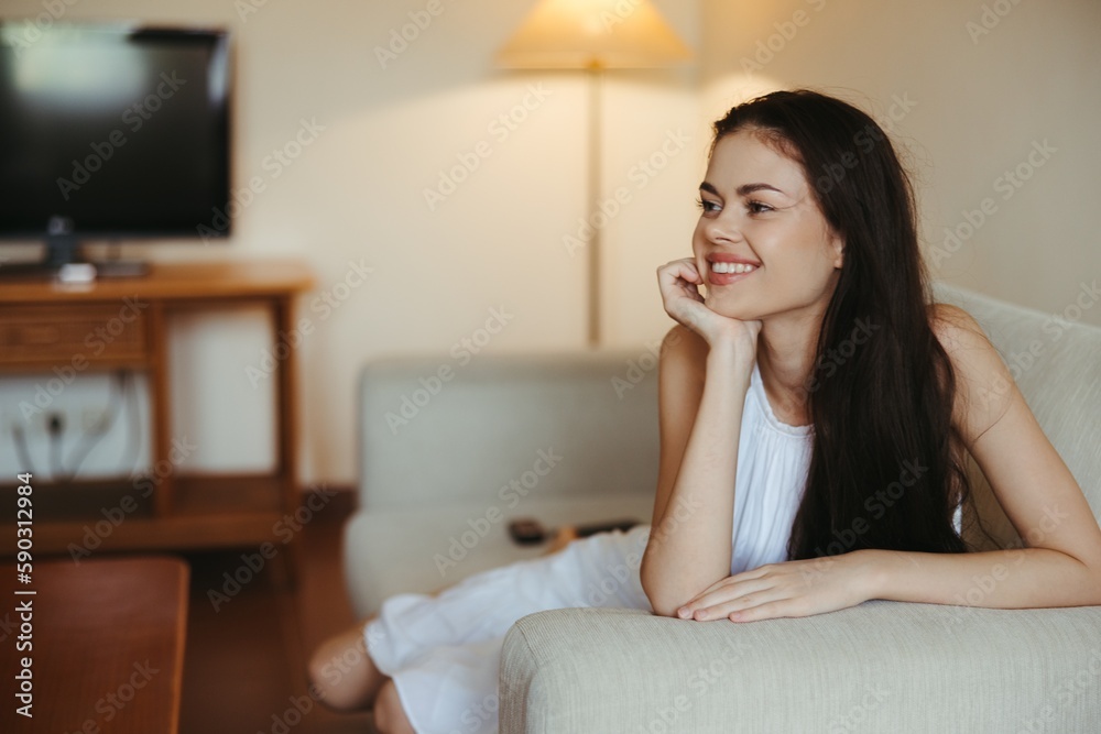 Happy girl smile lying on the couch at home, relaxing at home, comfort, sunshine. Happy girl smile lying on the couch at home, relaxing at home, comfort, sunshine.