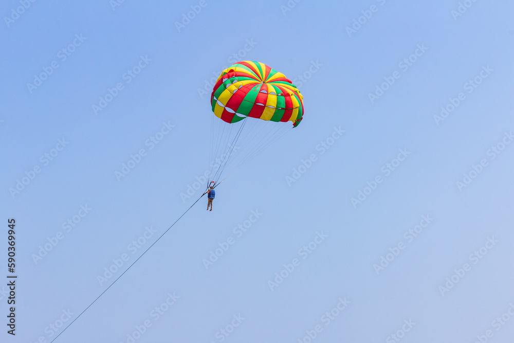 joyful carefree childhood, silhouette of Happy child teenager Parasailing on blue sky, shallow DOF joyful carefree childhood, silhouette of Happy child teenager Parasailing on blue sky, shallow DOF
