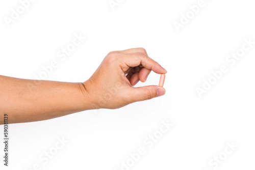 Hand holding a capsule or pill isolated on white background.