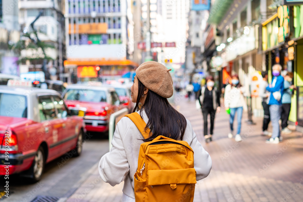 Young woman traveler walking in the Mong Kok in Hong Kong, Mong Kok is one of the major shopping areas in Hong Kong