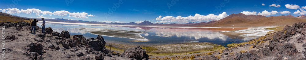 Scene of salt lagoon reflecting mountains and clouds as if in a mirror.