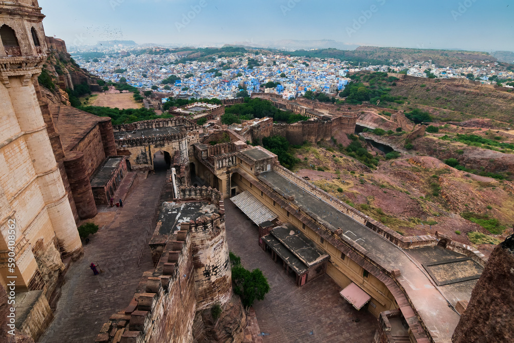 Jodhpur, Rajasthan, India - 19.10.2019 : Top view of Mehrangarh fort with distant view of blue city of Jodhpur. Blue sky in the background. Historical Fort is UNESCO world heritage site.