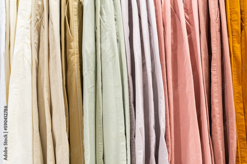 Selective focus, Fashion , clothes concept ,Clothes or pants many colors hang on a shelf in a designer clothes store. Clothing hanging on a clothing rack in a store.