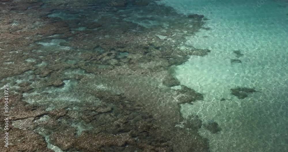 Fast moving clouds shadows reflections on an ocean with transparent water and reef Fast moving clouds shadows reflections on an ocean with transparent water and reef