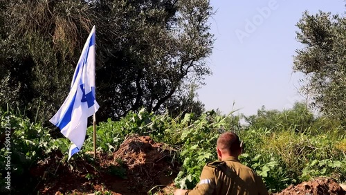 Israeli soldier runs up to the waving Israel Flag puts on an IDF army beret and salutes the main symbol of Israel. Video concept: IDF, Israeli Memorial Day, soldiers Israel photo