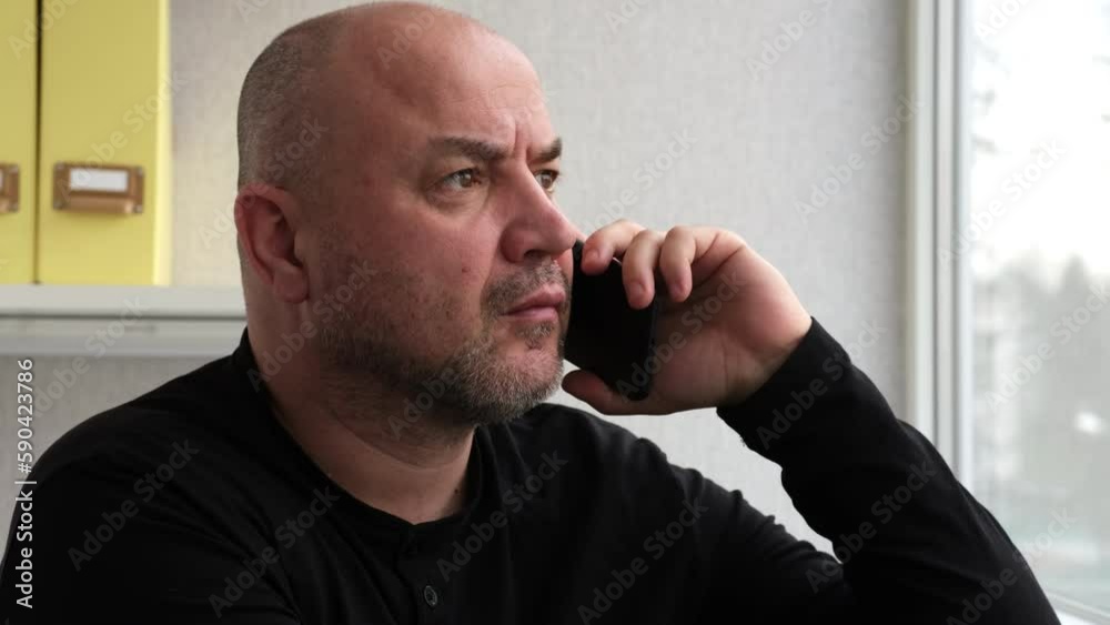 Closeup serious man talking mobile phone in office. Businessman or worker having phone call at workplace close up. Portrait of business man calling smartphone indoor Closeup serious man talking mobile phone in office. Businessman or worker having phone call at workplace close up. Portrait of business man calling smartphone indoor