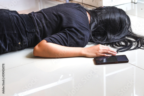 Fényképezés Woman fainted on the floor at home, phone fallen near her hand