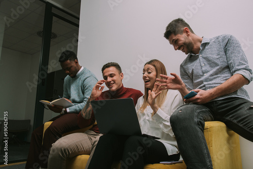 Fototapeta Naklejka Na Ścianę i Meble -  Happy coworkers finally found what was the problem about the solution of their daily task at work. They are sitting on a sofa and smiling