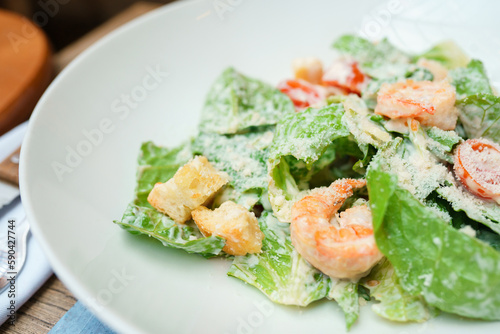 Caesar salad with shrimp on a white plate