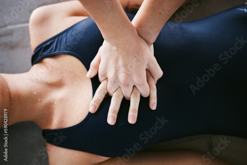 Hands, cpr and first aid with help of lifeguard for emergency, drown or accident after swimming. Sports, breathing and resuscitation of woman, rescue of athlete or saving life of swimmer in top view. photo