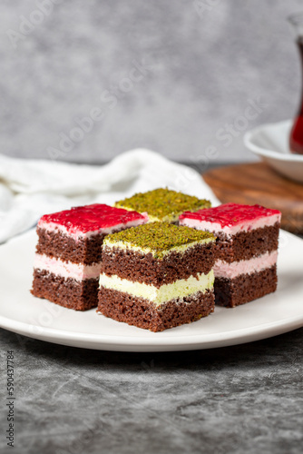 Small cake slices. Pistachio and raspberry cake slices. Set of different tartlets or cakes. Bakery products. Close up