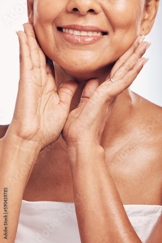 Hands, mouth and skin with a mature woman in studio for beauty, anti aging treatment or cosmetics. Skincare, facial and wellness with a senior female moisturizing her face for hydration closeup