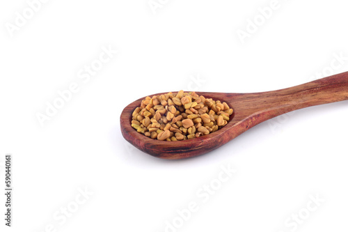 Fenugreek seeds in wooden spoon isolated on white background